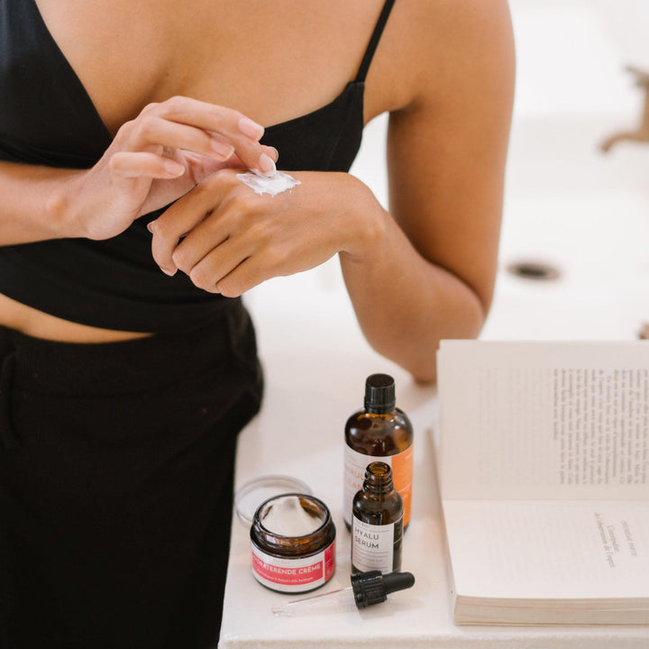 Een vrouw brengt crème aan op haar hand met Hydraterende Crème met Collageen en Retinol. Vermindert rimpels en houdt de huid gehydrateerd en gevoed.