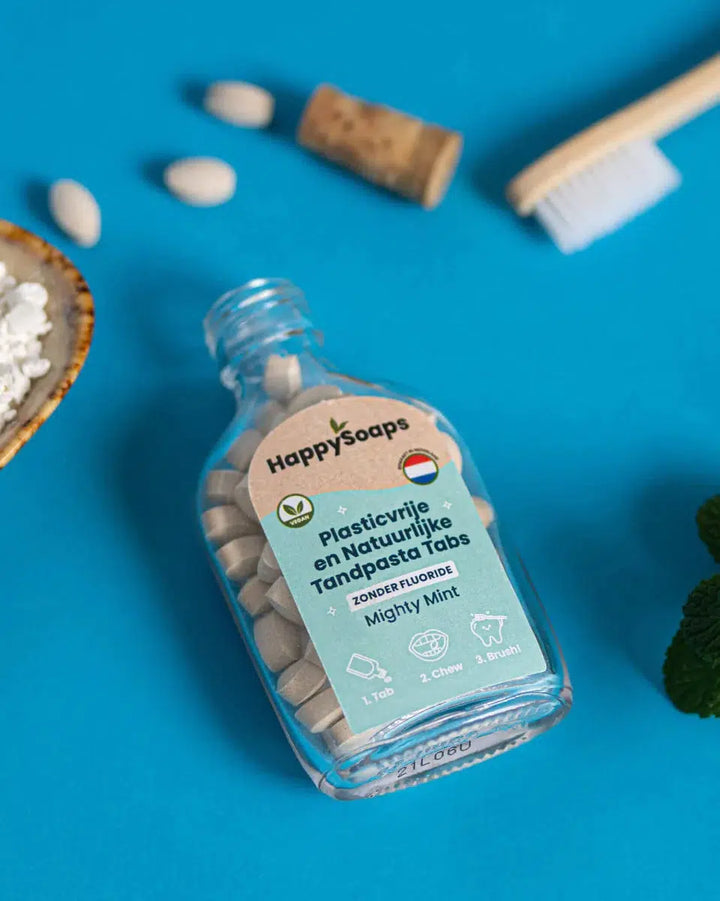 Een flesje witte pillen met Tandpasta Tabs - Zonder Fluoride - Mighty Mint, een duurzaam alternatief voor plastic tandpasta tubes. Makkelijk in gebruik: kauw op een tablet en poets je tanden met het schuim voor een effectieve reiniging.
