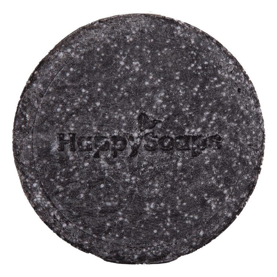 Een zwarte ronde shampoo bar met tekst - The Happy Panda. Handgemaakt in Nederland met bamboe, geactiveerd houtskool, sheaboter, quinoa en olijfolie. Geschikt voor intense reiniging en herstel van hoofdhuid en haar. 100+ wasbeurten zonder plastic afval. Eenvoudig in gebruik.