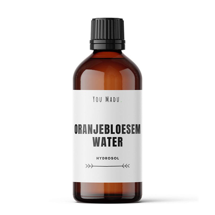 Een bruine fles met een wit label, Oranjebloesemwater (hydrosol), ideaal als reiniger, toner, badadditief, haarconditioner, parfum, deodorant en mondwasmiddel.